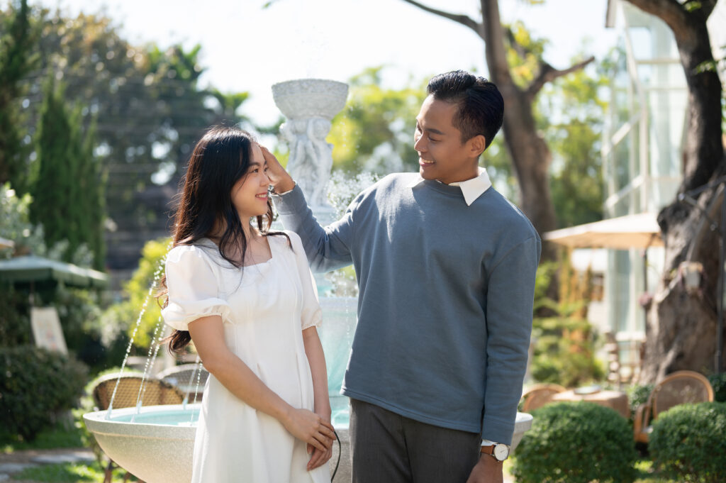 Lovely sweet young Asian couple walking in a beautiful park on a sunny day together. Relationship, love, bonding, girlfriend and boyfriend